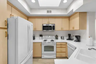 a kitchen with a white refrigerator and a stove at The Nautilus Waterfront Retreat Marina View, Pool Sauna Gym Jacuzzi in Los Angeles