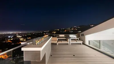 a balcony with a view of a city at night at Hollywood Hills 6BR Luxury Home w Pool, Theater & Panoramic Views in Los Angeles