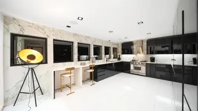 a kitchen with black cabinets and a yellow orb on a tripod at Hollywood Hills 6BR Luxury Home w Pool, Theater & Panoramic Views in Los Angeles