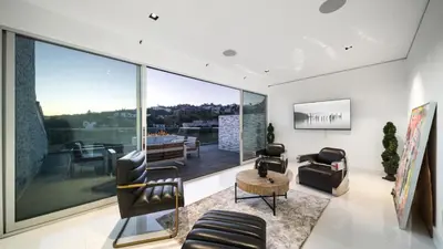 a living room with furniture and a large window at Hollywood Hills 6BR Luxury Home w Pool, Theater & Panoramic Views in Los Angeles