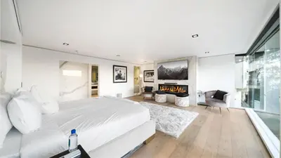 a bedroom with a large bed and a fireplace at Hollywood Hills 6BR Luxury Home w Pool, Theater & Panoramic Views in Los Angeles