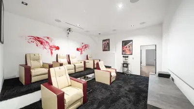 a waiting room with couches and red fishes on the wall at Hollywood Hills 6BR Luxury Home w Pool, Theater & Panoramic Views in Los Angeles