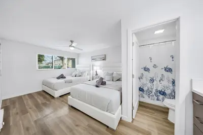 a white bedroom with two beds and a mirror at Oneluxstay Near Redondo Beach in Redondo Beach