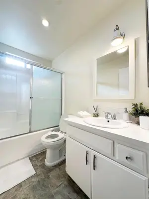a white bathroom with a toilet and a sink at 2BR Bohemian Haven Near Walk of Fame - BR6 - BUR in Burbank