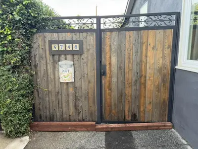 a wooden gate with a door with a sign on it at No Ho Casita in North Hollywood