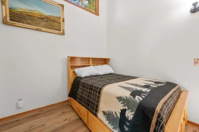 a bedroom with a bed with a blanket on it at Lakeview Bear Cubs Den - Walk to Lake, Close to Slopes in Big Bear Lake