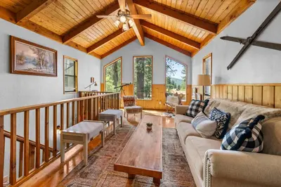 a living room with a couch and a table at Colibri Cabin - Walk to Lake and Trails in Big Bear Lake