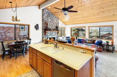 a kitchen with a sink and a living room at Lakeview Retreat - Walk to Lake, Close to Slopes in Big Bear Lake