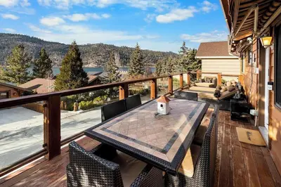 a wooden deck with a table and chairs on a balcony at Lakeview Retreat - Walk to Lake, Close to Slopes in Big Bear Lake