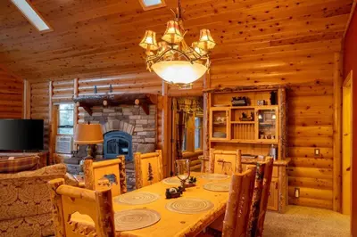 a dining room with a table and a fireplace at Foster’s Cabin - Close to Lake and Slopes in Big Bear City