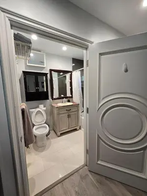 a bathroom with a toilet and a sink at Entire Luxurious Vaulted Haven with Pool in Tarzana