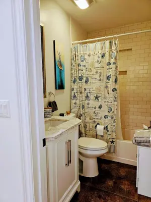 a bathroom with a toilet and a shower curtain at Entire Luxurious Vaulted Haven with Pool in Tarzana