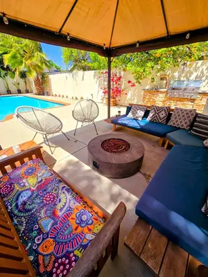 a patio with couches and a table and an umbrella at Entire Luxurious Vaulted Haven with Pool in Tarzana