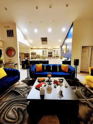 a living room with a blue couch and a table at Entire Luxurious Vaulted Haven with Pool in Tarzana