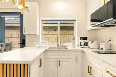 a kitchen with white cabinets and a sink at Lyn's Stay in Westminster
