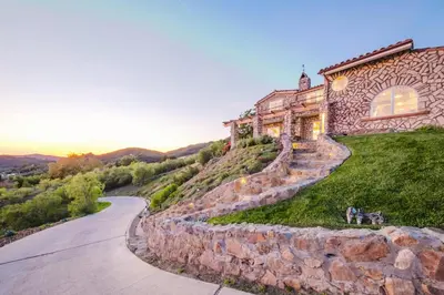 a stone house on a hill with a road at Mintcello Estate in Malibu