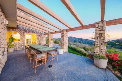 a patio with a table and chairs and flowers at Mintcello Estate in Malibu