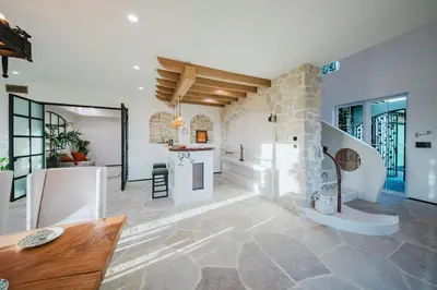a living room with a stone wall and a table at Mintcello Estate in Malibu