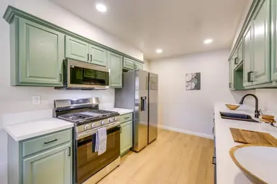 a kitchen with green cabinets and a stove at Walkable Home Base Near LLUMC and Campus! in Loma Linda