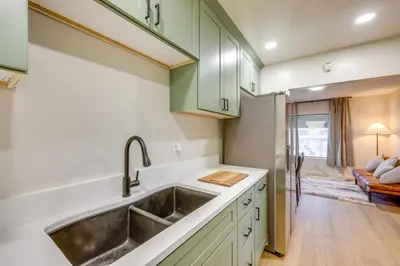 a kitchen with green cabinets and a sink at 1 Mi to LLUMC! Loma Linda Home with Shared Patio in Loma Linda