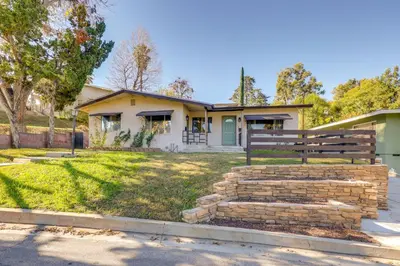 a house with a bench in front of a yard at 1 Mi to LLUMC! Loma Linda Home with Shared Patio in Loma Linda