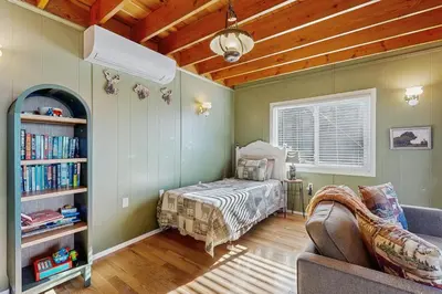 a bedroom with a bed and a book shelf at Lakeview Cabin in Crestline