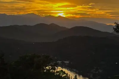 a sunset over a river with mountains in the background at Lakeview Cabin in Crestline