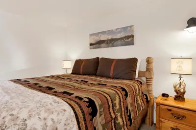 a bedroom with a bed and two lamps on a nightstand at Sweet Dream Cabin on Dream Street | Walk to Alpine Slide, Dining, & Big Bear Fun in Big Bear Lake