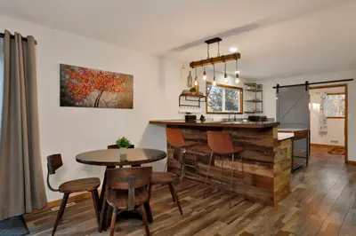 a kitchen with a bar and a table and chairs at The Highland Getaway at Big Bear Village | Downtown Modern Retreat Cottage in Big Bear Lake