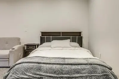 a bed with a blanket and a chair in a room at 5 Mi to Santa Monica Pier and Beach Chic Studio in Los Angeles