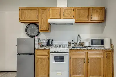 a kitchen with wooden cabinets and a white refrigerator at 5 Mi to Santa Monica Pier and Beach Chic Studio in Los Angeles
