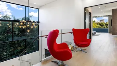two red chairs in a room with large windows at Private LA Retreat w Pool Hot Tub Fire Pit Near Melrose Ave The Martel House by AvantStay in Los Angeles