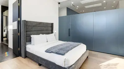 a bedroom with a large bed and a blue wall at Private LA Retreat w Pool Hot Tub Fire Pit Near Melrose Ave The Martel House by AvantStay in Los Angeles