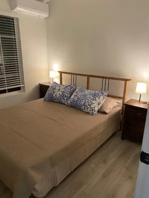 a bedroom with a bed with two lamps and a window at 530 sq ft Mini House in Walnut in Walnut