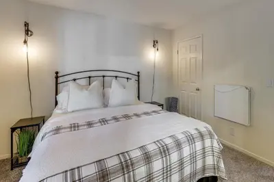 a bedroom with a bed with white sheets and pillows at 2 Decks! Pet-Friendly Lake Arrowhead Cabin in Lake Arrowhead