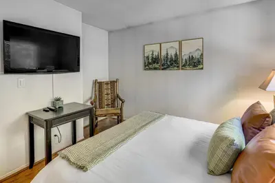a bedroom with a bed and a desk and a tv at 2 Decks! Pet-Friendly Lake Arrowhead Cabin in Lake Arrowhead