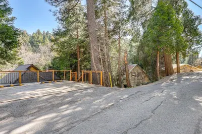 a gate on the side of a road with trees at 2 Decks! Pet-Friendly Lake Arrowhead Cabin in Lake Arrowhead
