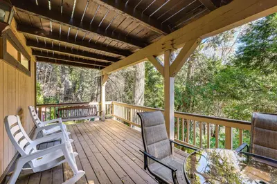 a porch with rocking chairs and a glass table at 2 Decks! Pet-Friendly Lake Arrowhead Cabin in Lake Arrowhead