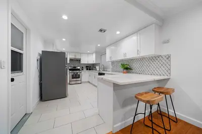 a kitchen with white cabinets and a stainless steel refrigerator at Marbella Lane - Serene & Spacious 3BR Haven in West Covina