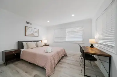 a bedroom with a bed and a desk and a window at Marbella Lane - Serene & Spacious 3BR Haven in West Covina