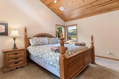 a bedroom with a wooden bed and a window at Boulder Cove։ Lakefront Estate in Big Bear Lake