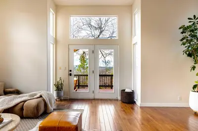 a living room with a large glass door and wooden floors at Lakeview Mountain Modern in Lake Arrowhead