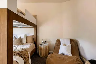 a bedroom with a bed and a mirror and a chair at Lakeview Mountain Modern in Lake Arrowhead