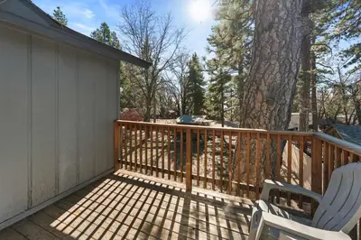 a balcony with two chairs and a tree at The Hidden Pines Mountain Home by Navigate Stays in Running Springs