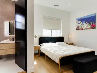 a bedroom with a large bed and a bathroom at Modern Luxe Retreat Four-Bedroom in Los Angeles