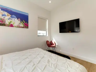 a bedroom with a bed and a television on the wall at Modern Luxe Retreat Four-Bedroom in Los Angeles