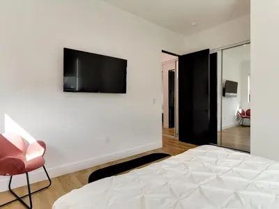 a bedroom with a bed and a television on a wall at Modern Luxe Retreat Four-Bedroom in Los Angeles