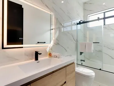 a bathroom with a sink and a toilet and a mirror at Modern Luxe Retreat Four-Bedroom in Los Angeles