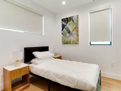 a white bedroom with a bed and a window at Modern Luxe Retreat Four-Bedroom in Los Angeles