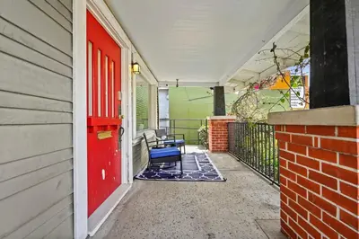 a porch with a red door and a blue chair at 1 mile from the Beach Fire Pit, Patio, Parking! in Long Beach